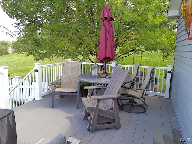 wooden terrace featuring a lawn