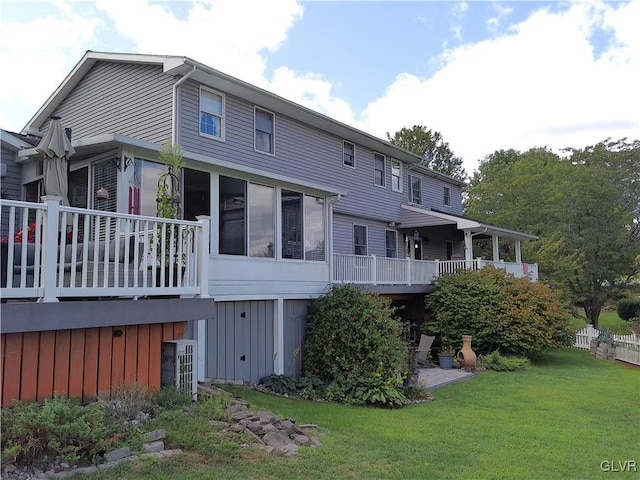 rear view of property with central AC unit, a lawn, and a sunroom