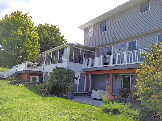 rear view of property with a patio, a sunroom, and a lawn