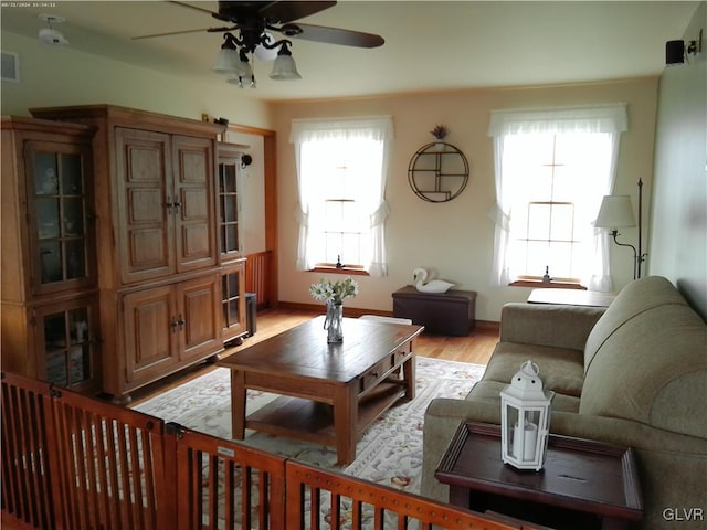 living room featuring light hardwood / wood-style flooring and ceiling fan