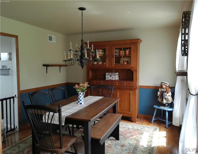 dining room featuring a chandelier, light wood-type flooring, and visible vents