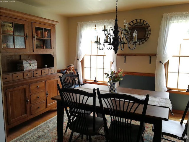 dining space featuring hardwood / wood-style flooring and an inviting chandelier