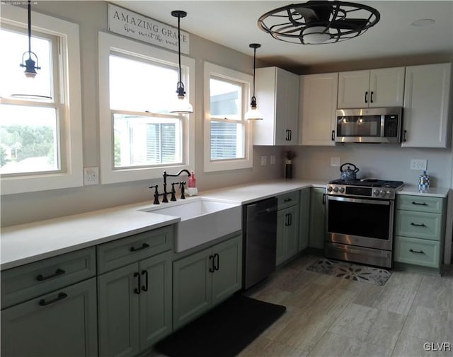 kitchen with sink, decorative light fixtures, and stainless steel appliances