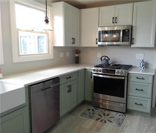 kitchen featuring stainless steel appliances, white cabinets, and hanging light fixtures