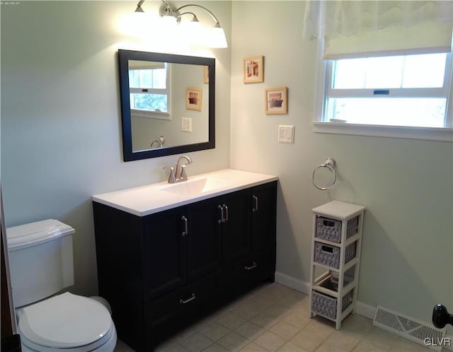 bathroom with visible vents, toilet, vanity, tile patterned flooring, and baseboards