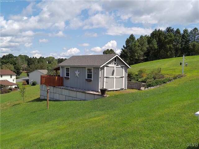 exterior space featuring a lawn and a storage shed