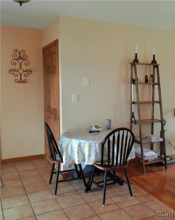 dining room with baseboards and light tile patterned floors