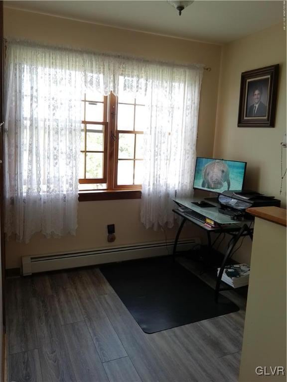 office area with a baseboard heating unit and hardwood / wood-style flooring