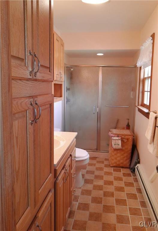 bathroom featuring toilet, a stall shower, a baseboard heating unit, and vanity