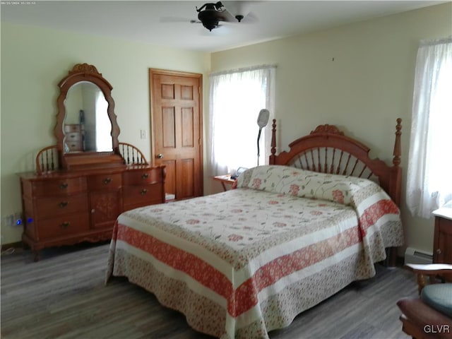 bedroom featuring hardwood / wood-style floors, a baseboard radiator, and ceiling fan