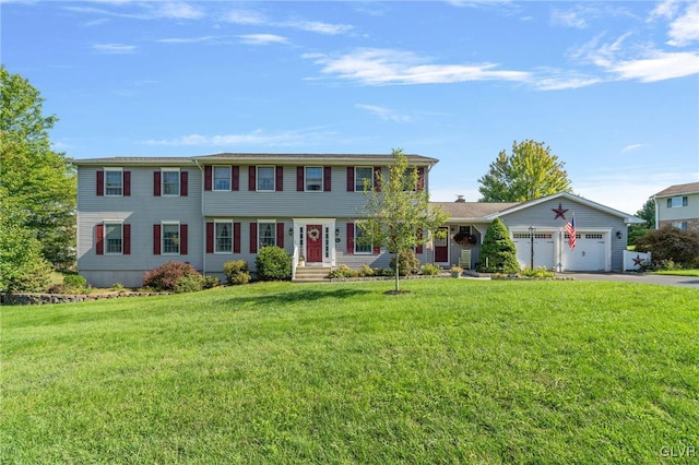 view of front of house featuring driveway, a garage, and a front yard