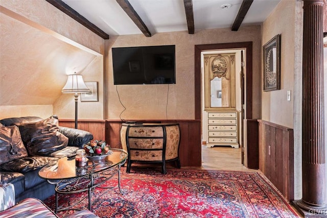 living room featuring beamed ceiling and wood-type flooring