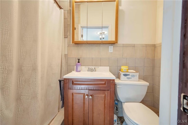 bathroom with a shower with curtain, toilet, tasteful backsplash, vanity, and tile walls