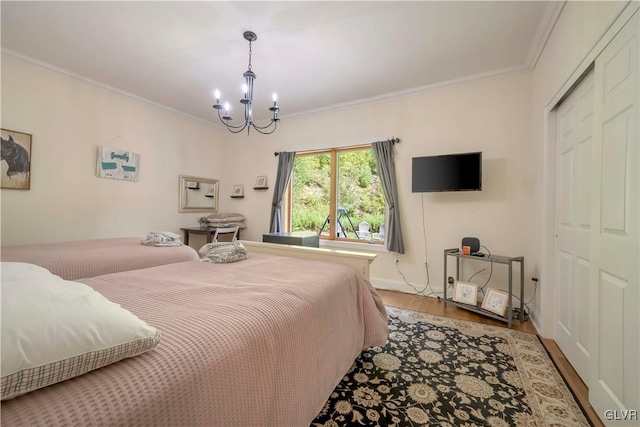 bedroom featuring hardwood / wood-style flooring, a closet, crown molding, and a chandelier