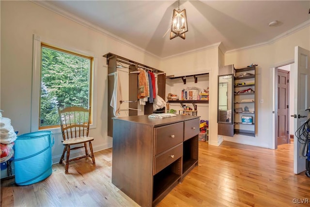 interior space with plenty of natural light, light hardwood / wood-style floors, ornamental molding, and hanging light fixtures