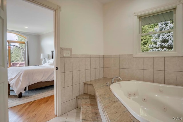 bathroom featuring plenty of natural light, a bathtub, ornamental molding, and wood-type flooring