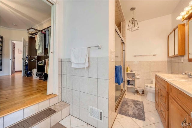 bathroom featuring ornamental molding, vanity, tile walls, toilet, and hardwood / wood-style flooring