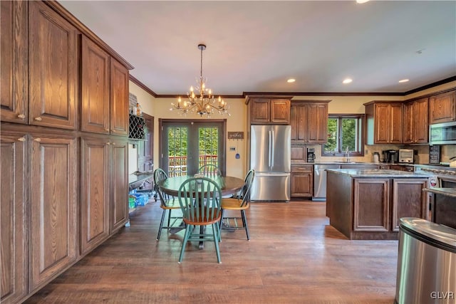 kitchen with hardwood / wood-style flooring, a kitchen island, a healthy amount of sunlight, and stainless steel appliances