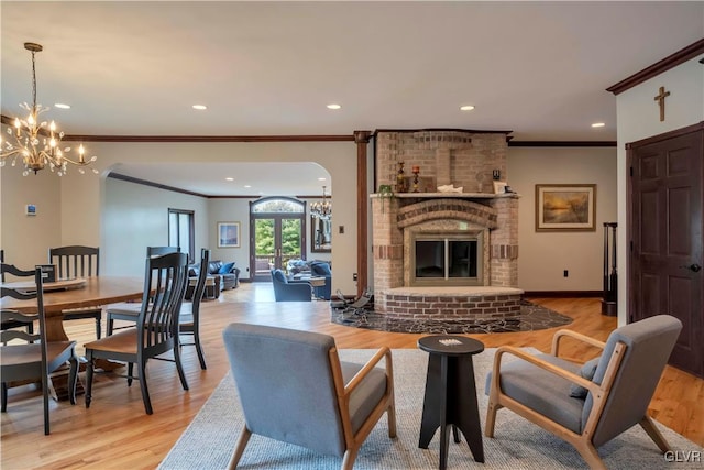 living room with crown molding, light hardwood / wood-style flooring, and a brick fireplace