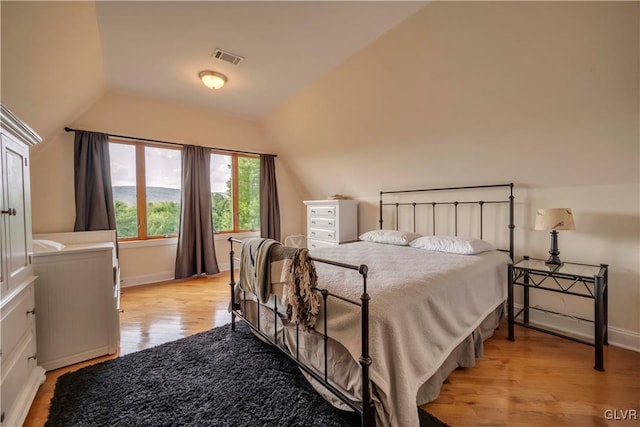 bedroom featuring lofted ceiling and light hardwood / wood-style floors