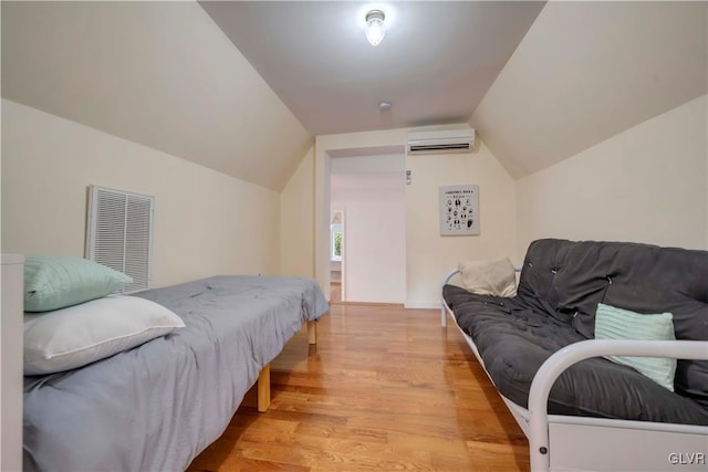 bedroom with lofted ceiling, light wood-type flooring, and a wall unit AC