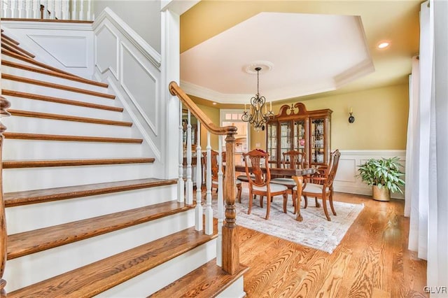 stairs featuring hardwood / wood-style floors and a notable chandelier