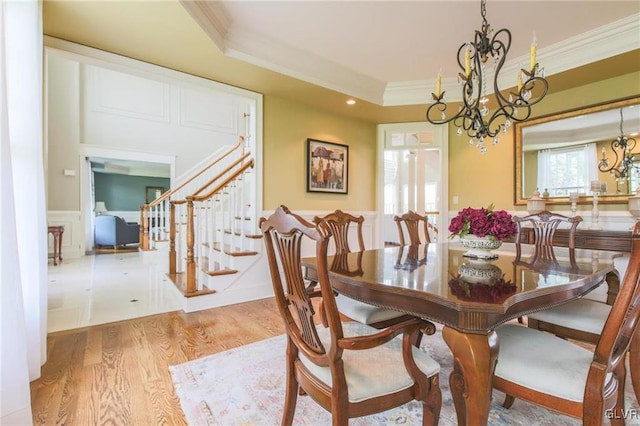 dining room with light hardwood / wood-style floors, a chandelier, and crown molding