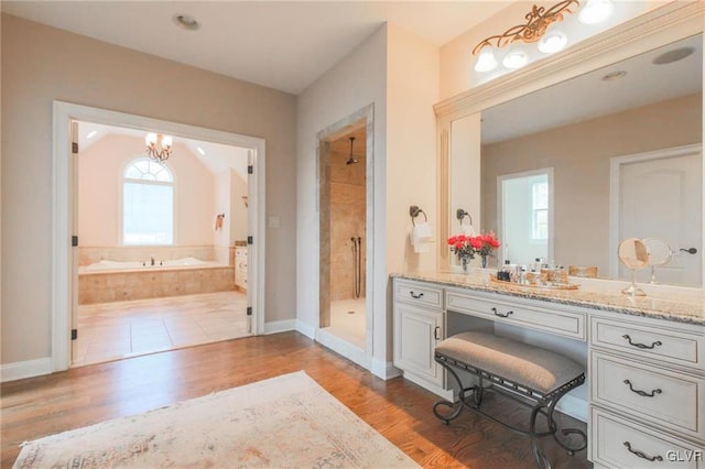 bathroom featuring vanity, a healthy amount of sunlight, and shower with separate bathtub