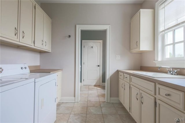 laundry area featuring washer and dryer, cabinets, sink, and light tile patterned flooring