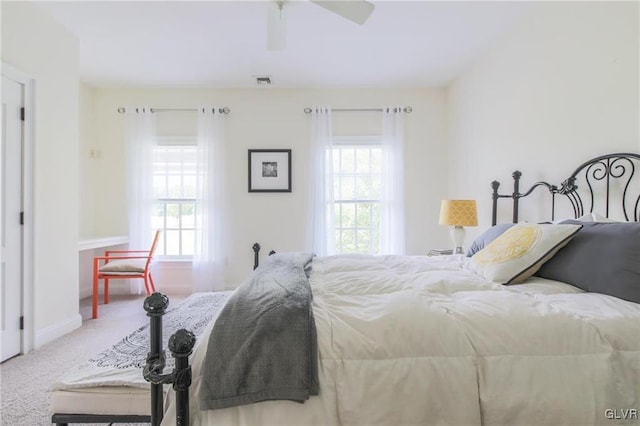 bedroom featuring multiple windows, ceiling fan, and carpet flooring