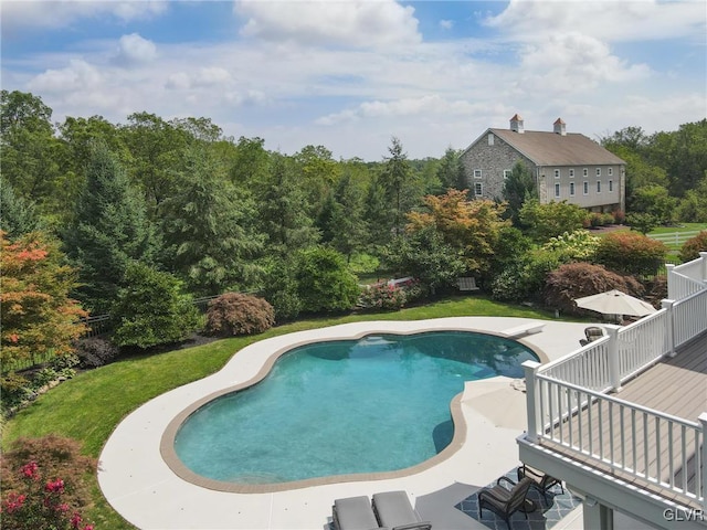 view of pool with a lawn and a patio