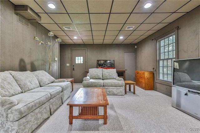 carpeted living room with a drop ceiling