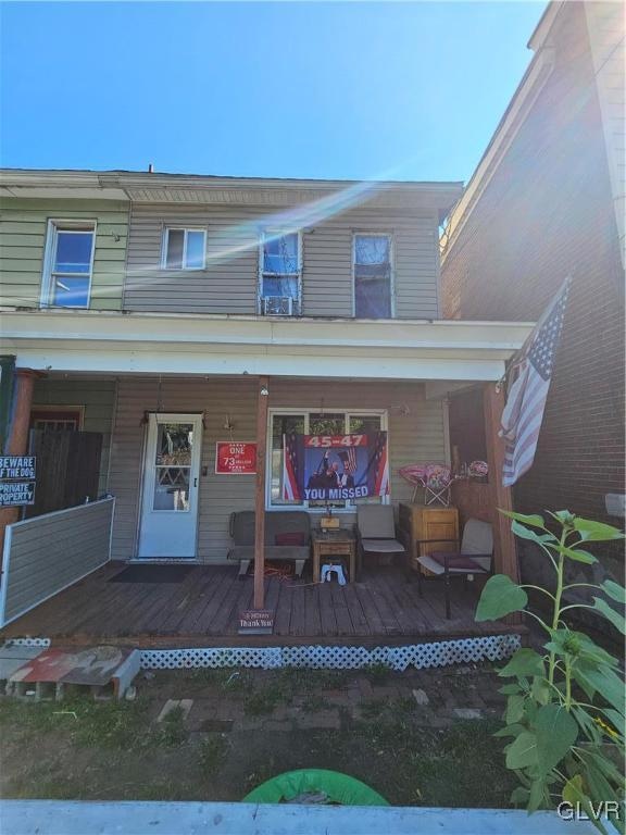 back of property featuring an outdoor living space and a deck