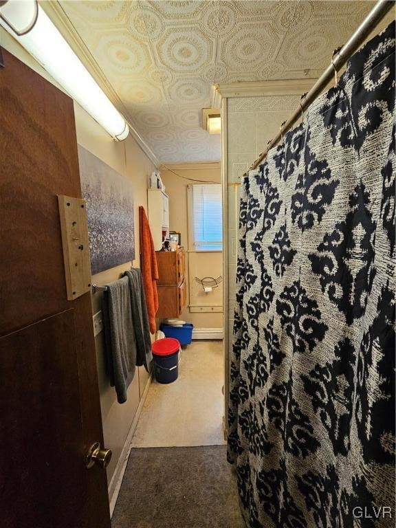 bathroom with a shower with curtain and ornamental molding