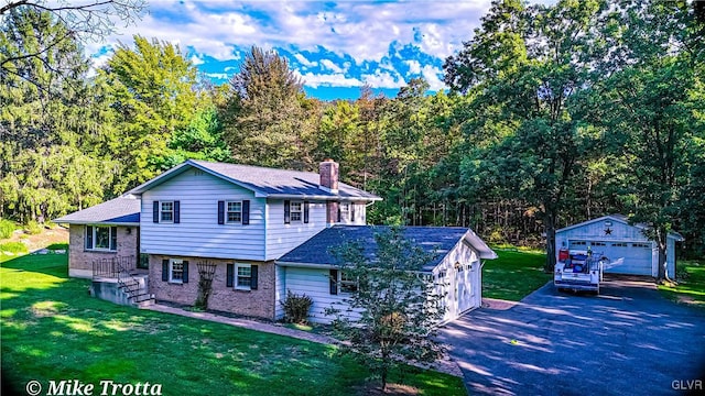 view of front of home with a garage, a front yard, and an outbuilding