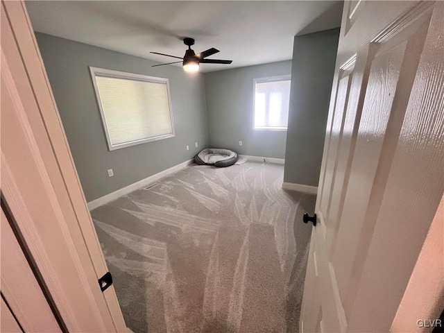 carpeted spare room featuring ceiling fan