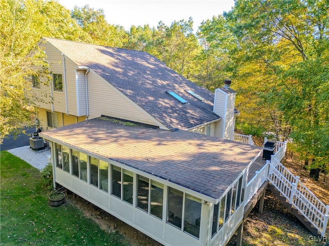 back of house with cooling unit and a sunroom