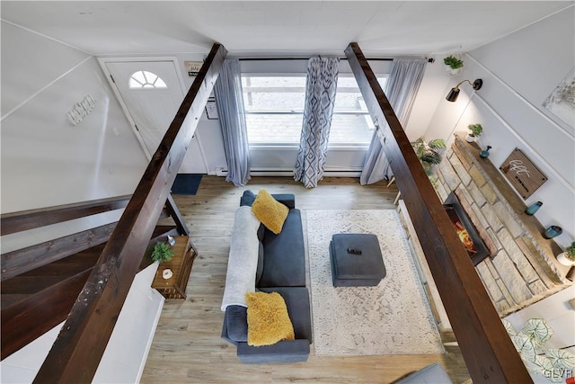 living room with wood-type flooring and a stone fireplace