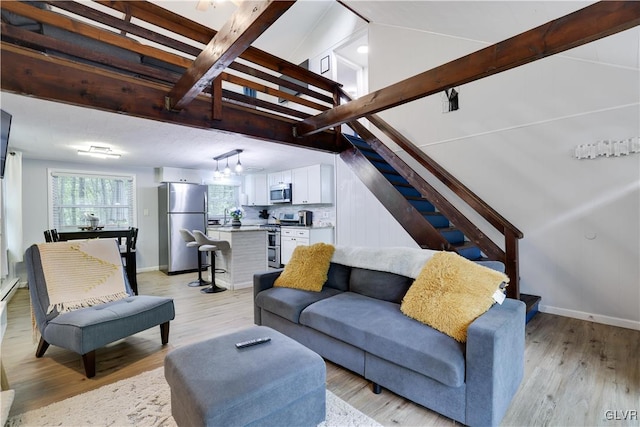 living room featuring light wood-type flooring and beamed ceiling