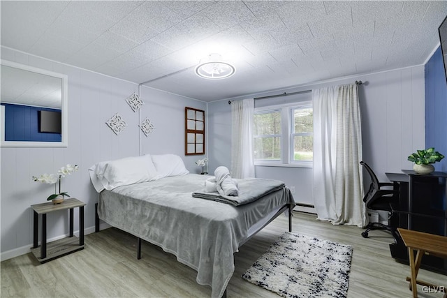 bedroom with light wood-type flooring and a baseboard radiator