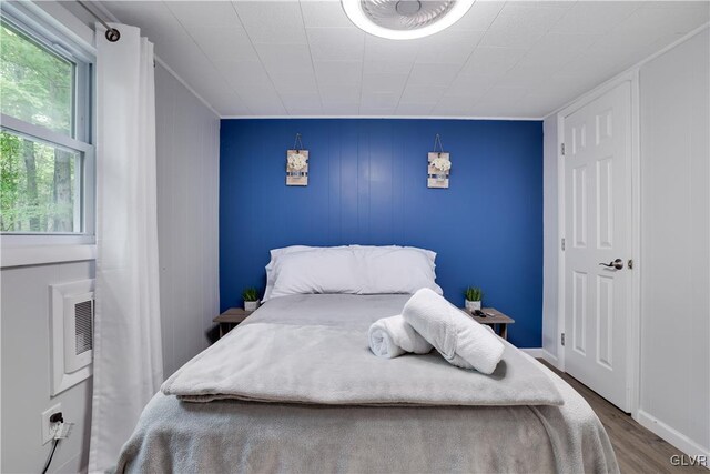 bedroom featuring wood-type flooring and wood walls