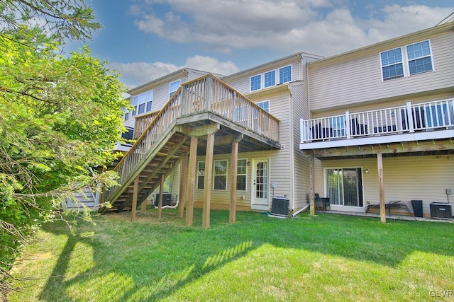 back of property with a wooden deck, a lawn, and central air condition unit