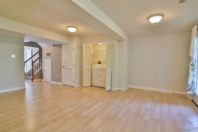 spare room with light hardwood / wood-style floors and washer / dryer