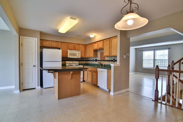 kitchen with a center island, a kitchen bar, decorative backsplash, white appliances, and decorative light fixtures