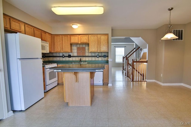 kitchen featuring backsplash, white appliances, a breakfast bar area, a center island, and decorative light fixtures