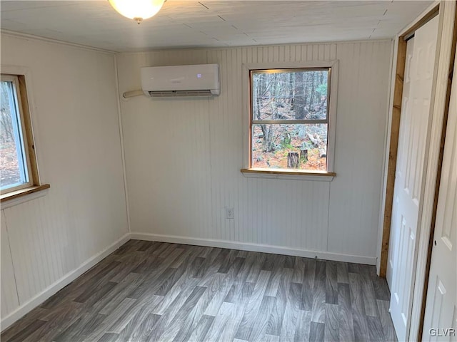 spare room with dark hardwood / wood-style flooring and a wall mounted air conditioner