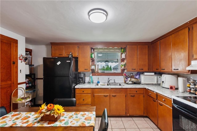 kitchen featuring black appliances, tasteful backsplash, light tile patterned floors, and sink