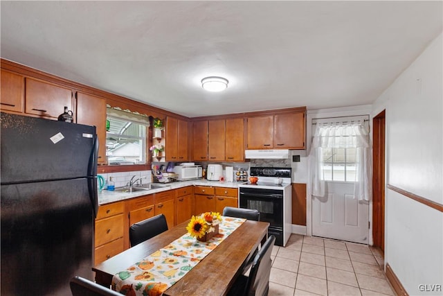 kitchen with light tile patterned floors, sink, decorative backsplash, electric range, and black fridge