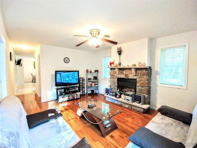 living room featuring hardwood / wood-style floors, a fireplace, and ceiling fan