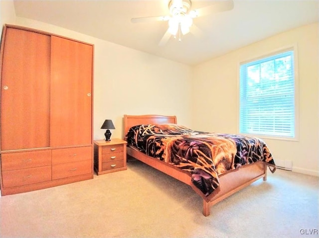 carpeted bedroom with a closet and ceiling fan